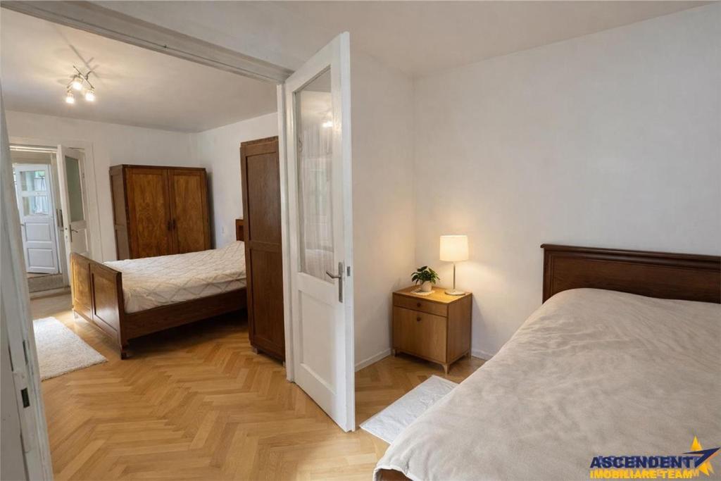 a bedroom with a bed and a door leading to a bedroom with a bedicter at Emese Central Square Vintage Apartment in Târgu-Mureş
