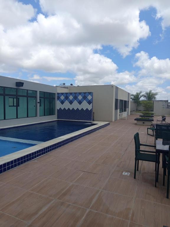 a building with a swimming pool and a patio at AP Evangelista in Caruaru