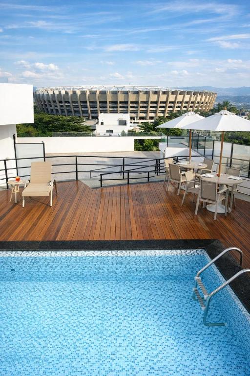 a pool on top of a building with tables and chairs at Stop Inn Plus Pampulha in Belo Horizonte