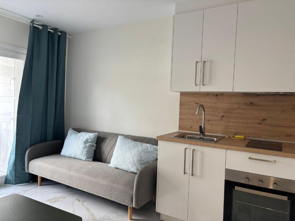 a living room with a couch and a kitchen at Marco Apartment By Torremolinos On-line in Torremolinos