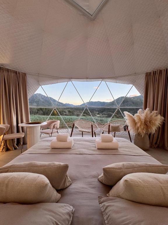 a bedroom with a large bed with a large window at Les Dômes du Moulin in Urtaca