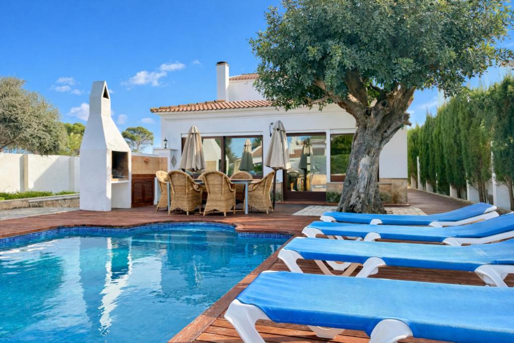 a villa with a swimming pool and lounge chairs at Villa Sa Punta in Cala en Blanes