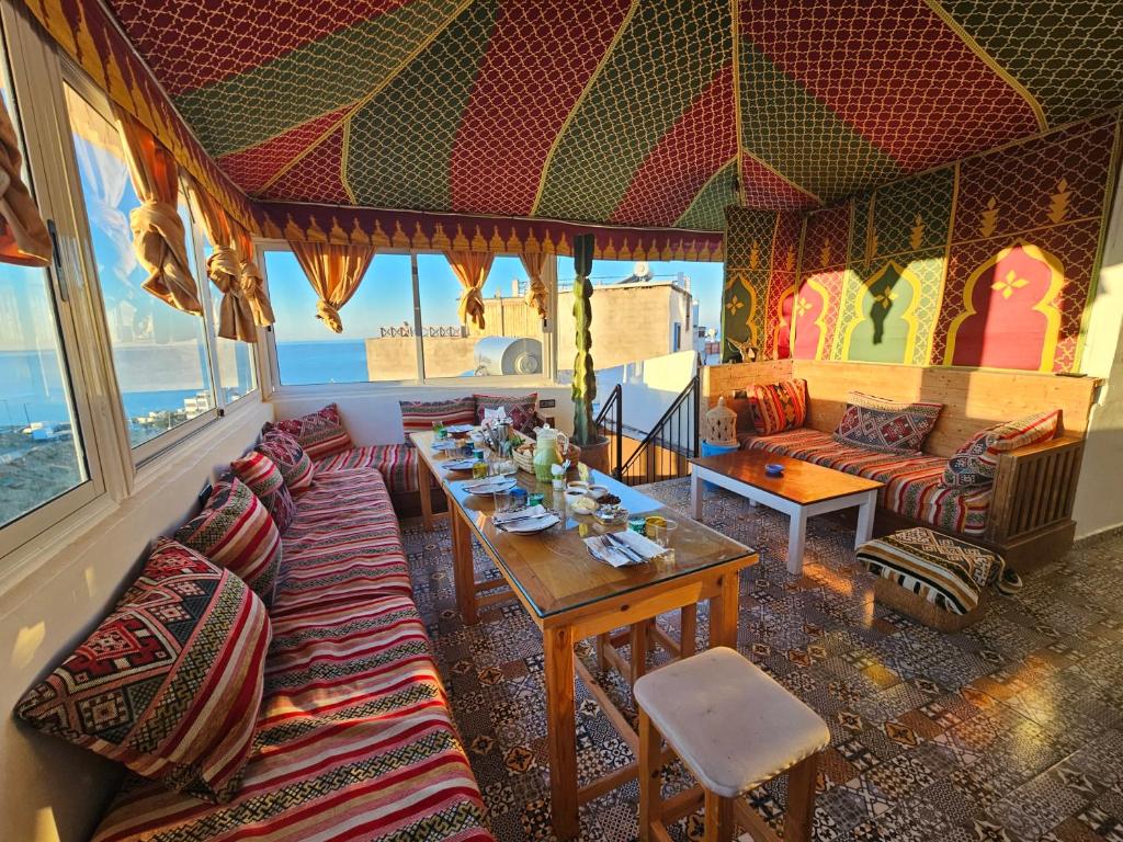 a living room with a table and a couch at Welle Surf House in Taghazout