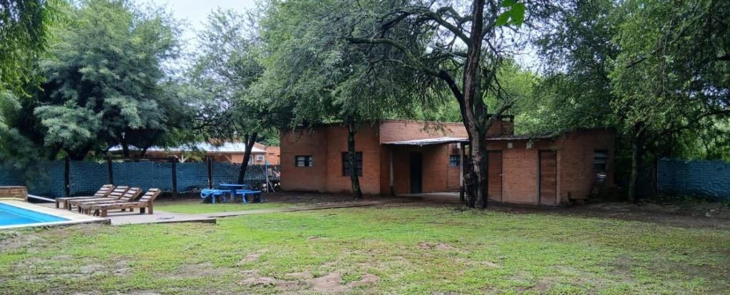 a house with a yard with a pool and a fence at Finca La Huella II in Santiago del Estero