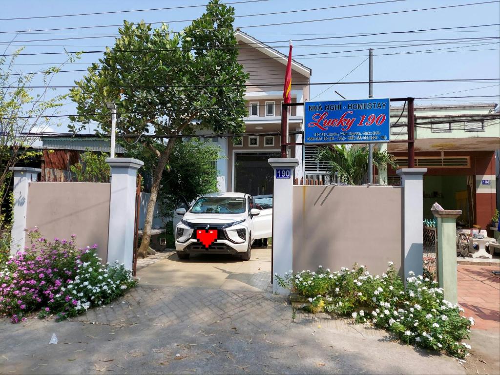 a car parked in front of a house with a sign at Lucky 190 in Chau Doc