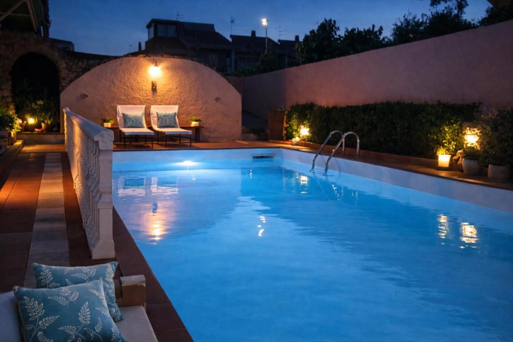 a swimming pool at night with lights on a building at Vincent house in Quartu SantʼElena