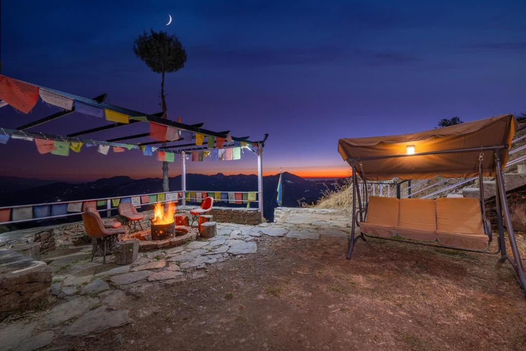 a tent and a fire pit on a patio at night at Gadegal Homestay Narkanda - Rooms & Pahadi Café in Shimla