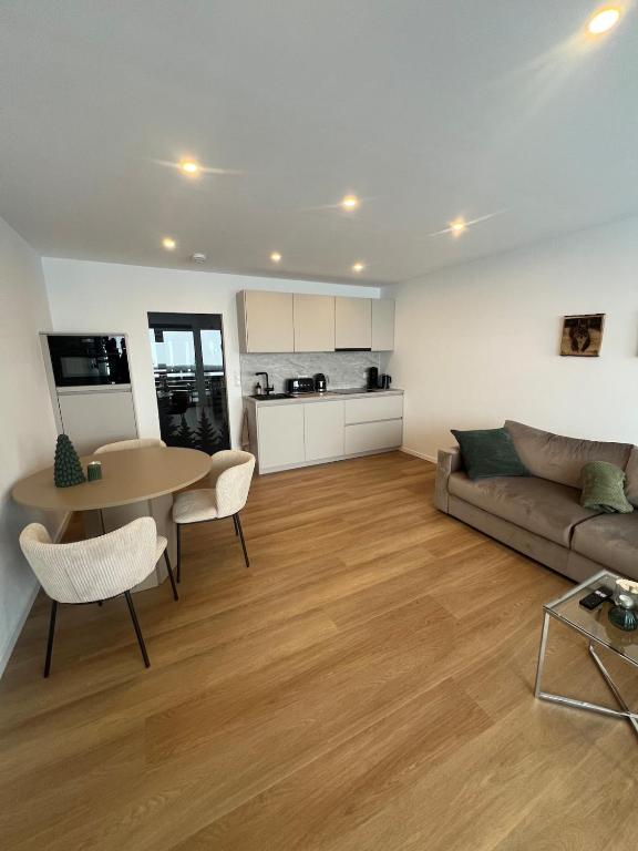 a living room with a couch and a table at Black Forest Vista - Pool Sauna Tennis in Schonach