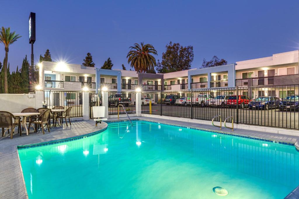 a swimming pool in front of a apartment building at Hotel Seville - Ontario Airport/Chino in Ontario