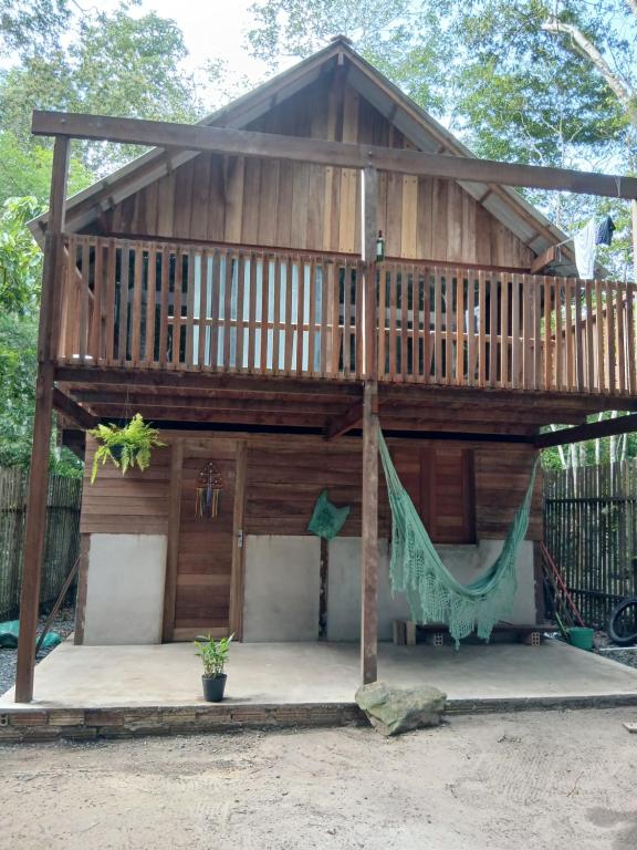 ein großes Holzhaus mit einer Hängematte davor in der Unterkunft Altér Chale in Santarém