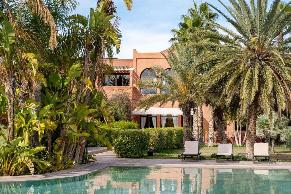 a resort with palm trees and a swimming pool at Bab Akoul Atlas - Boutique Hotel & Spa in Aït Namous