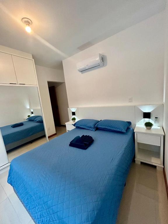 a bedroom with a blue bed with two blue pillows at Apê Ásia in Governador Celso Ramos