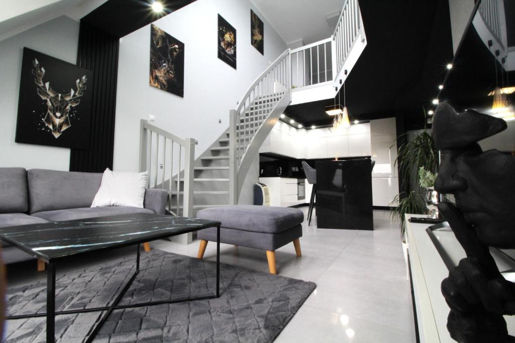 a living room with a staircase and a couch at Bulwar Apartament in Głogów