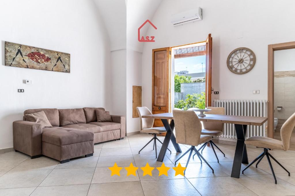 a living room with a couch and a table and chairs at Bovio28 - Nel Centro Del Salento in Carmiano