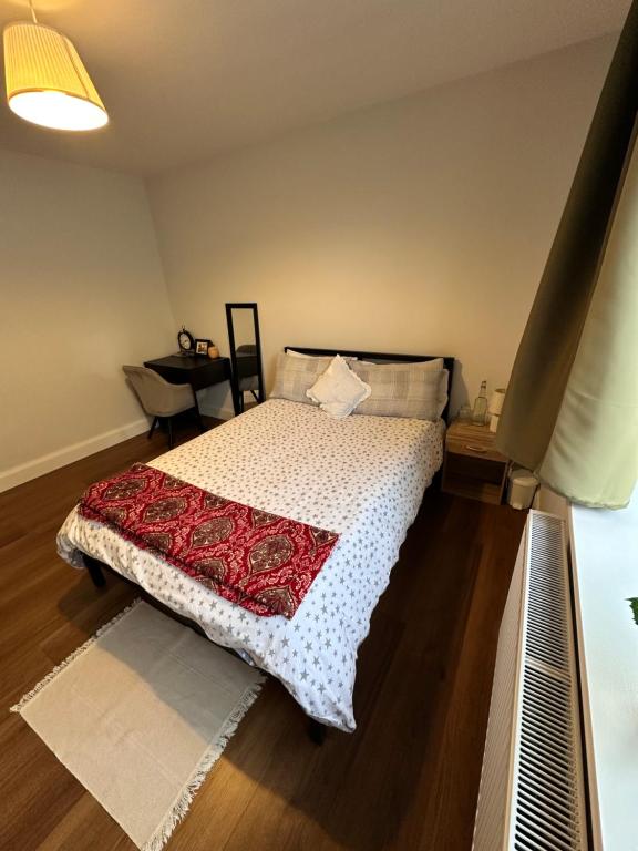 a bedroom with a bed with a red and white blanket at Home sweet home in Drogheda