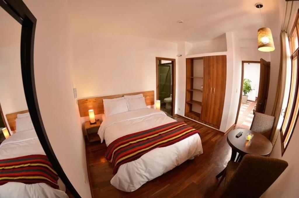 ein Hotelzimmer mit zwei Betten und einem Spiegel in der Unterkunft La Aurora in Huaraz