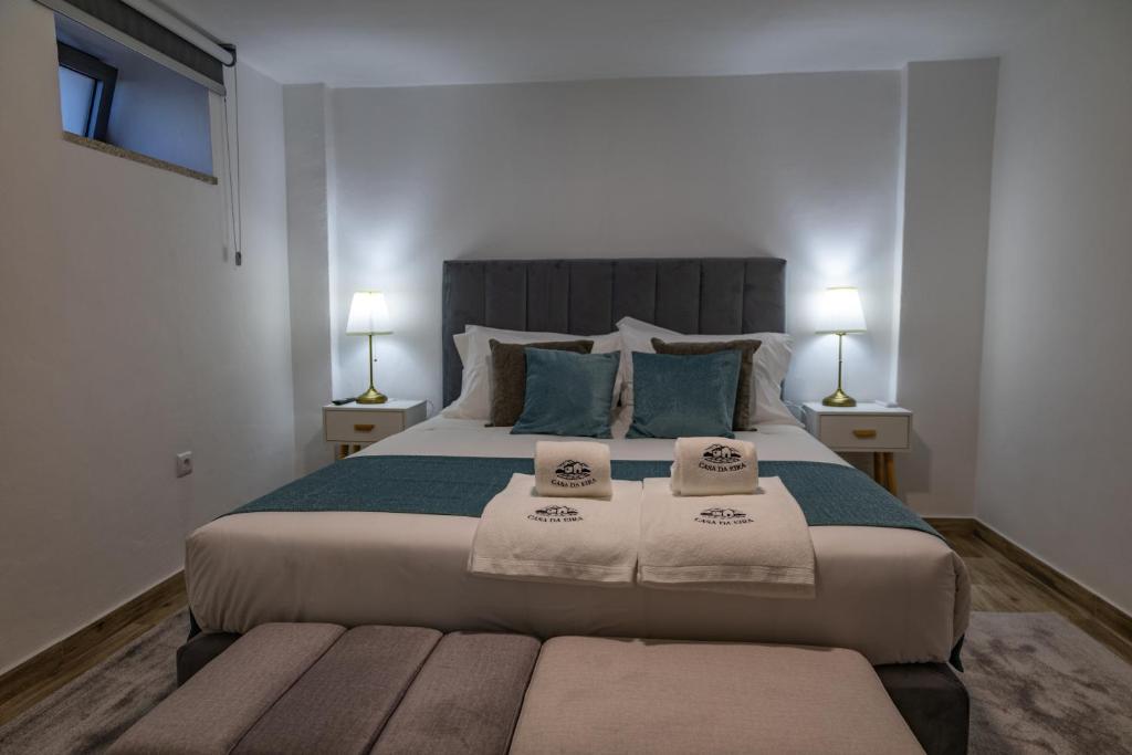 a bedroom with a large bed with towels on it at Casa da Eira Campia in Vouzela