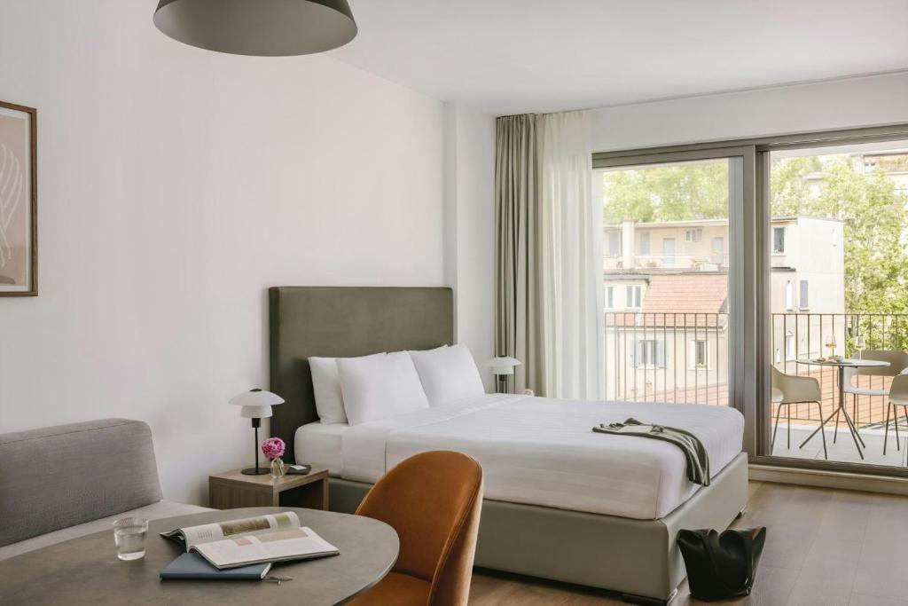 a hotel room with a bed and a balcony at Numa Milan Montenero in Milan