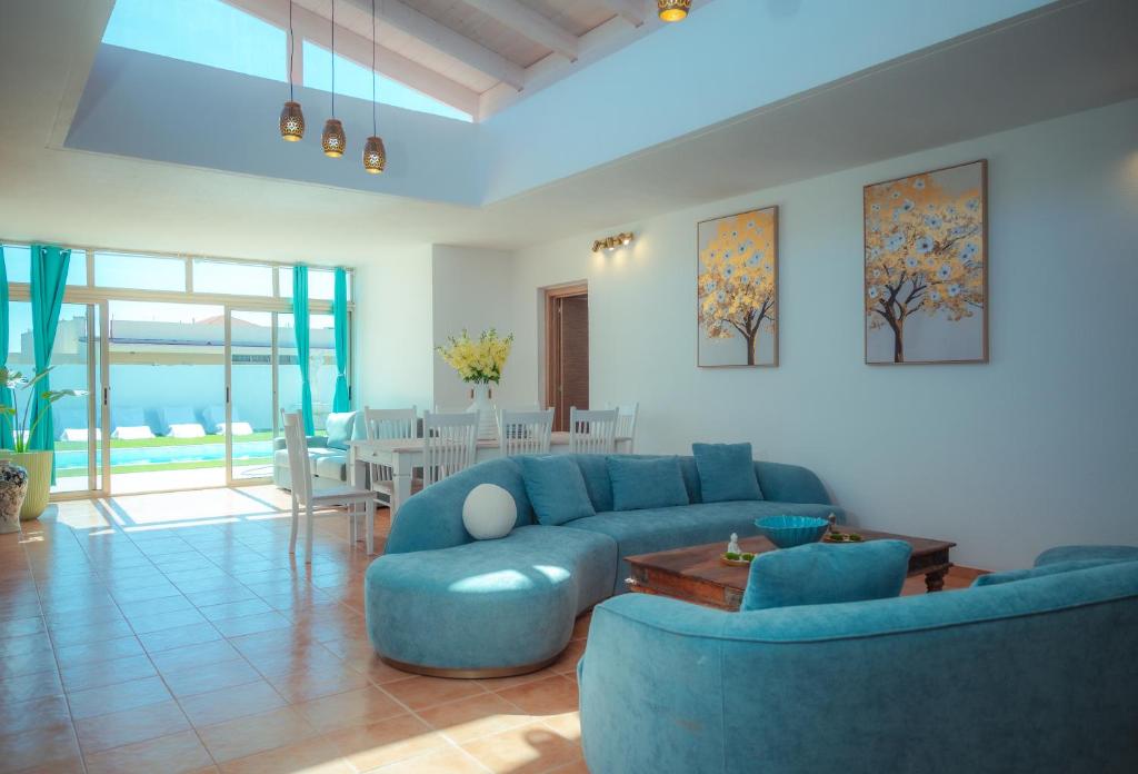a living room with a blue couch and a table at Chalet Molly92 in Antigua