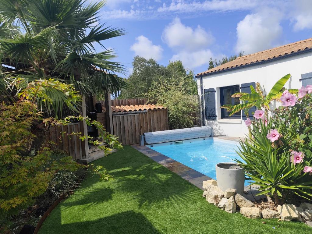 a backyard with a swimming pool in a yard at Villa L'Echappée Oléronaise in Saint-Georges-dʼOléron