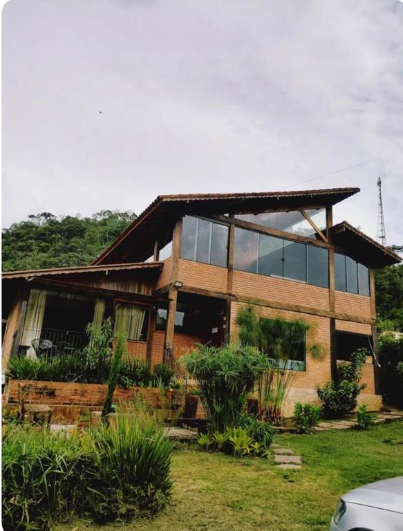 a house with glass windows on the side of it at Casa Reserva da Gávea Visconde de Mauá in Visconde De Maua