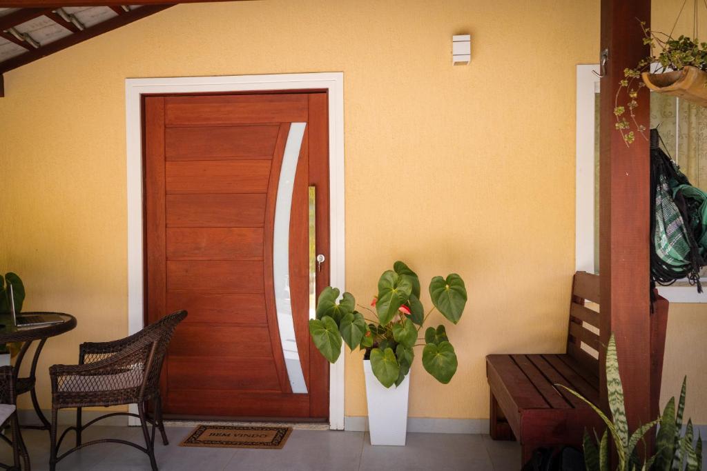 a door of a house with a plant next to it at Quarto Aconchegante Teresópolis Refúgio Cristão in Teresópolis