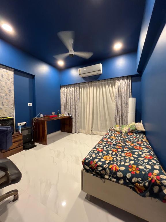a blue bedroom with a bed and a table at Sumeru in Mumbai