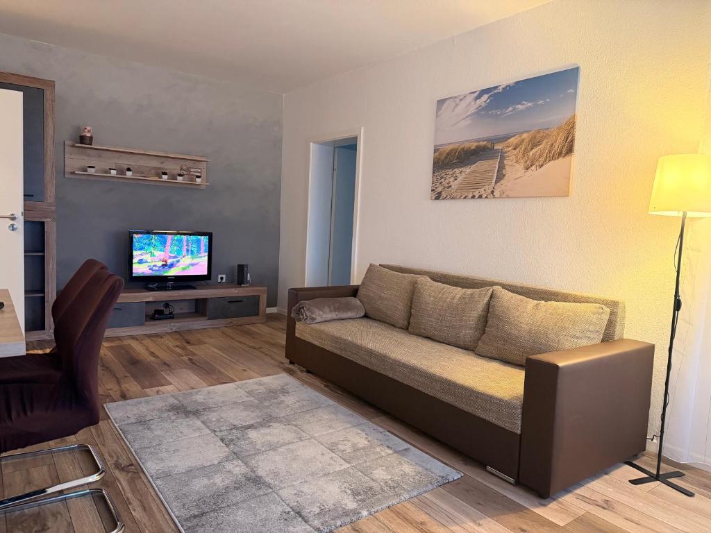 a living room with a couch and a television at Modern 2-Room Apartment with Free Parking and Balcony in Waldmohr