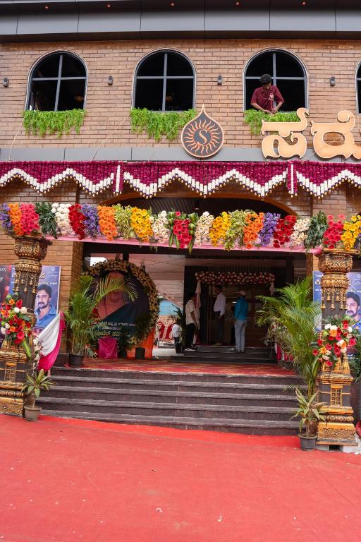 a building with a bunch of flowers in front of it at Hotel Sarovaras Legacy in Bangalore
