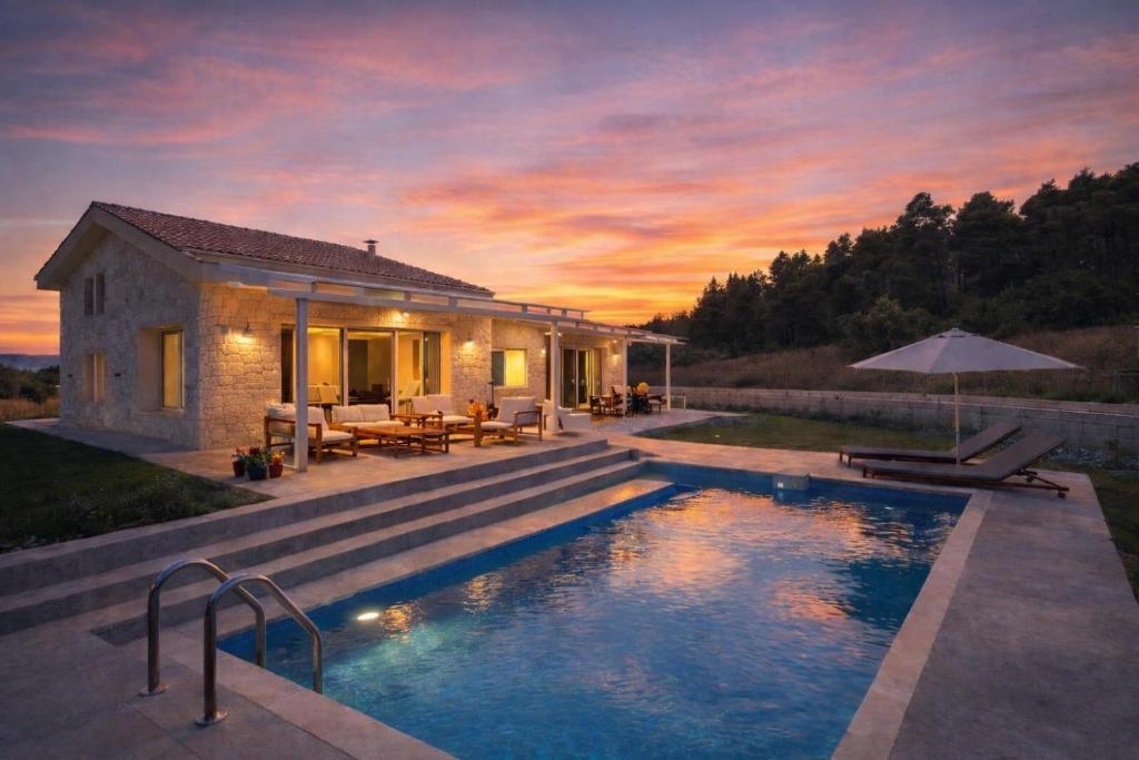 a villa with a swimming pool in front of a house at Villa Maria in Elani