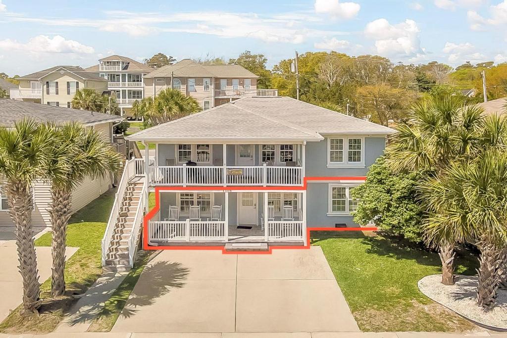 a large house with palm trees in front of it at Crescent Beach 3 Bedroom with Pool, Across the Street from Ocean in Myrtle Beach