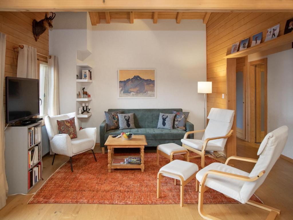 a living room with a green couch and white chairs at Apartment Ker Eol by Interhome in Villars-sur-Ollon