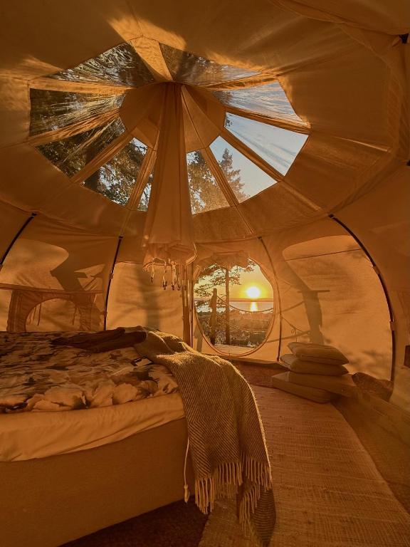 a room with a bed in a tent with a window at Gränna Glamping in Gränna