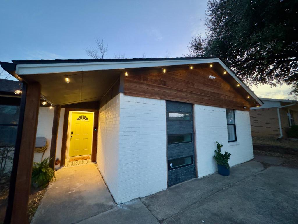 a small white garage with a yellow door on it at 5 Star Stay Large Remodeled Modern 4BR Near UNT and TWU Sleeps 10 in Denton