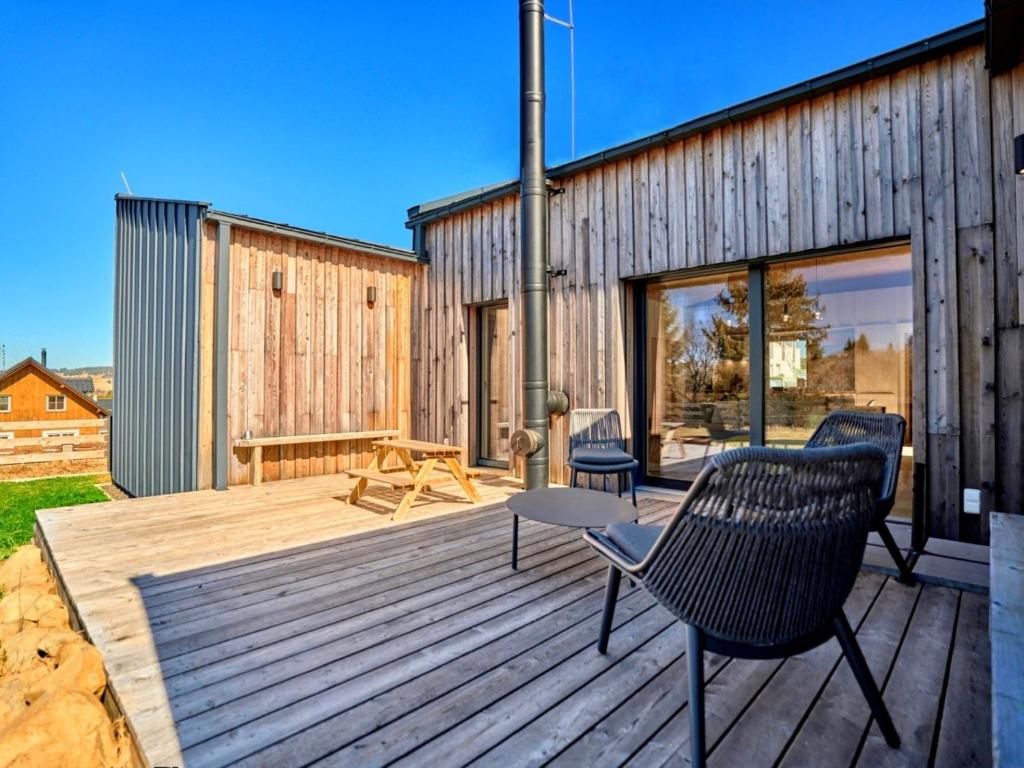a wooden deck with chairs and a building at Chalet Popcorn by Interhome in Abertamy
