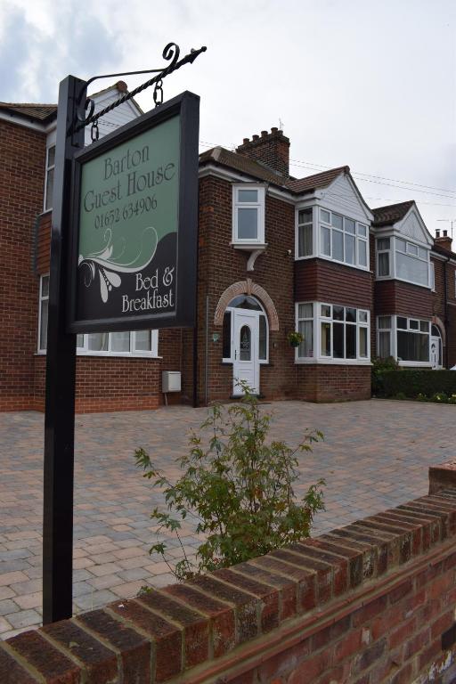 un cartel frente a una casa de ladrillo en Barton Guest House, en Barton-upon-Humber