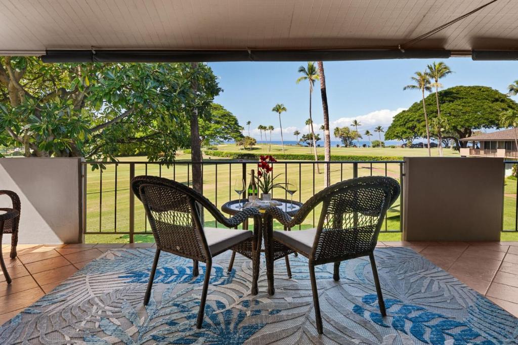 a table and chairs on a patio with a view at Maui Eldorado H202 in Kaanapali
