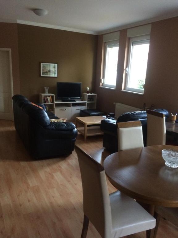 ein Wohnzimmer mit schwarzen Ledermöbeln und einem Tisch in der Unterkunft Aleksandar Apartment in Pančevo