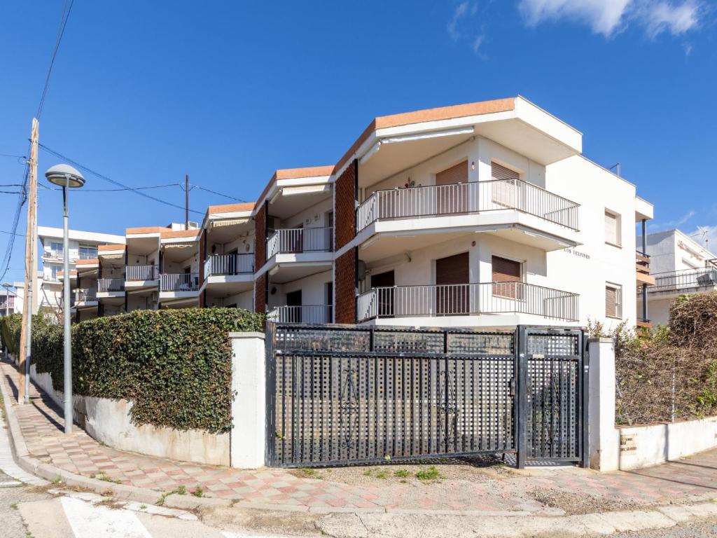 a white building with a fence in front of it at Apartment Delfines by Interhome in Cambrils
