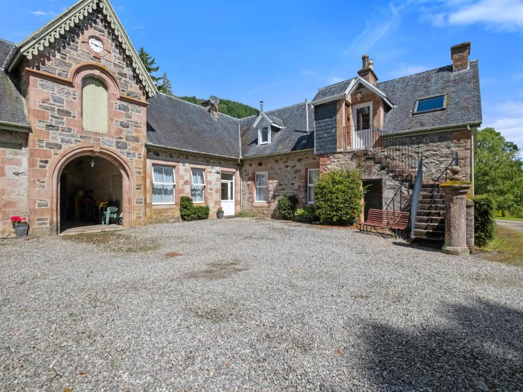 an old stone house with a large driveway at Apartment Pond View on Aigas Golf Course by Interhome in Beauly