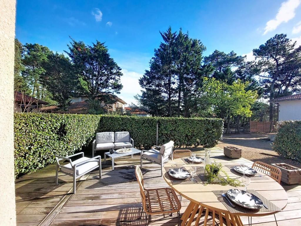 a patio with a table and chairs and trees at Holiday Home Bretons by Interhome in Capbreton