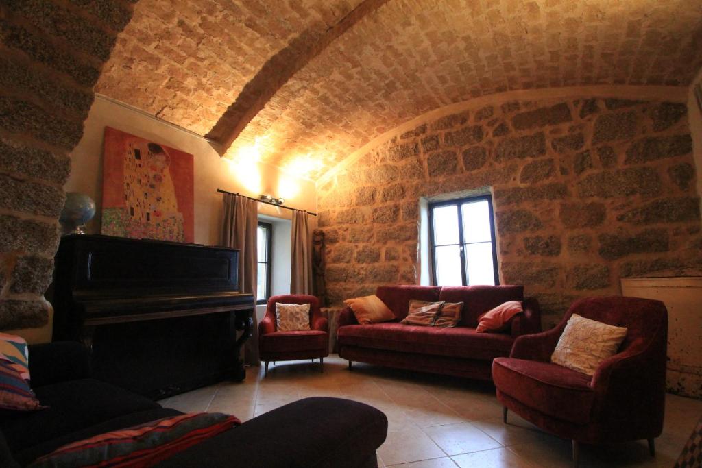 a living room with a couch and a piano at Casa Una Storia in Sartène