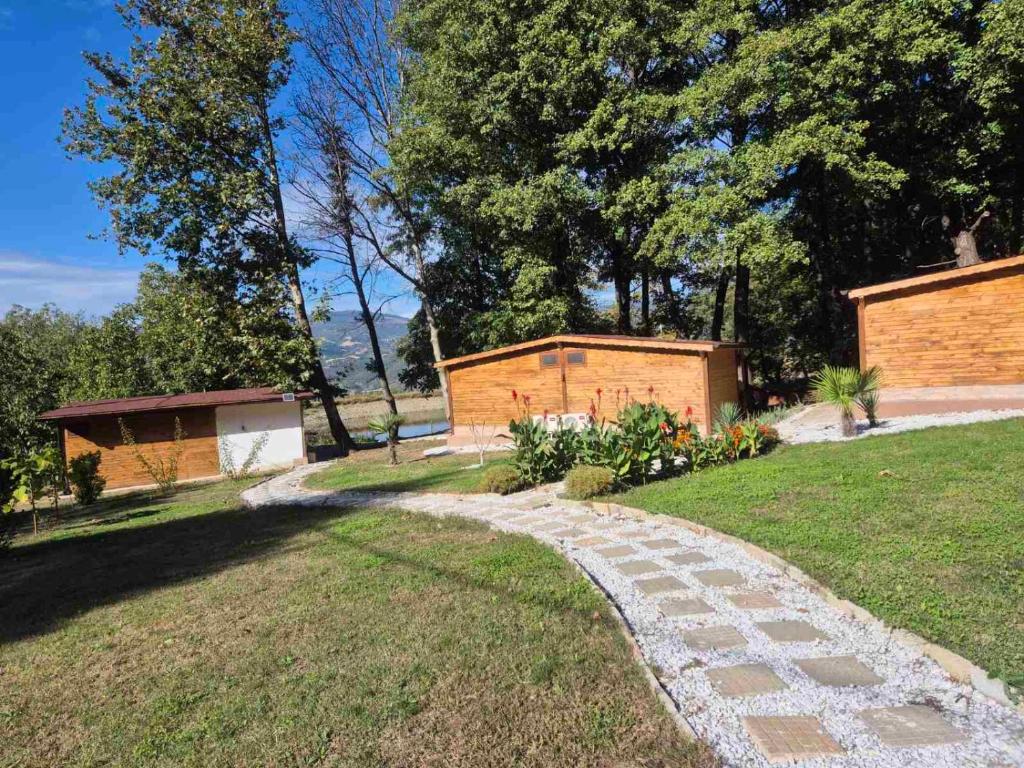a stone path in a yard with trees and a building at Бунгала ЛАГО in Gabrene