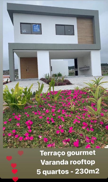 a house with pink flowers in front of it at Casa Ville Perignon in Gravatá