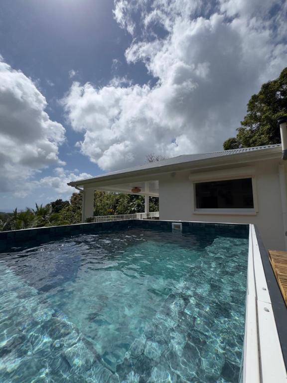 a swimming pool in front of a house at Villa Altura in Rivière-Salée