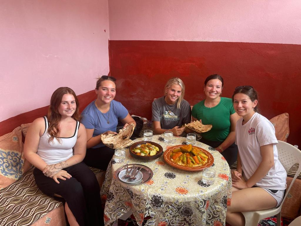 a group of women sitting around a table with food at Atlas House in Amizmiz