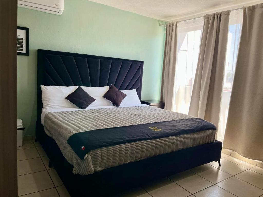 a bedroom with a bed with a blue headboard and a window at 1 VENATOR House Boutique in León