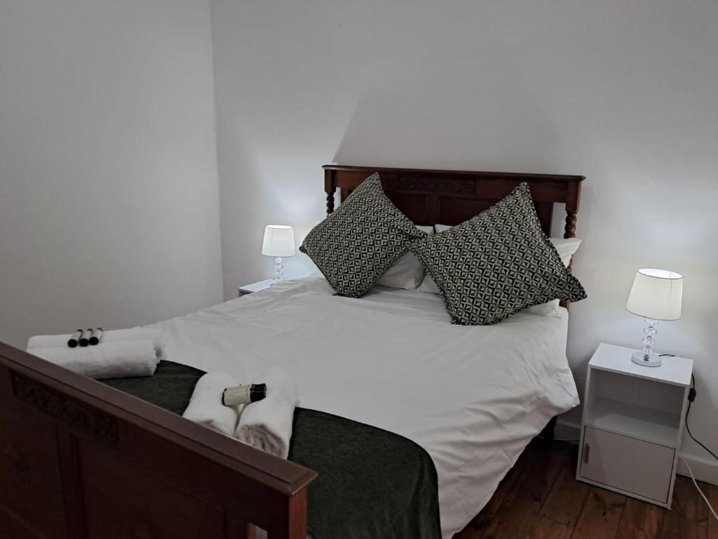 a bedroom with a large white bed with pillows at Eenvoud in Rosendal