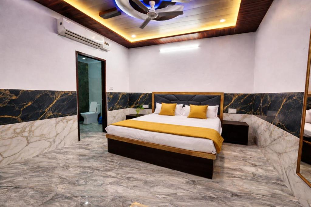 a bedroom with a bed and a ceiling fan at H0TEL PARBU KIRPAA Near Premanand Ji Maharaj Mandir Vrindavan in Chhatikara