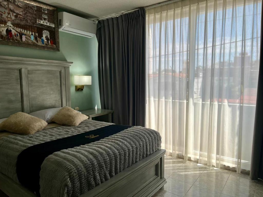 a bedroom with a bed and a large window at 5 VENATOR House Boutique in León